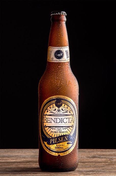 Garrafa Bendicta Pilsen 600ml Puro Malte em fundo escuro